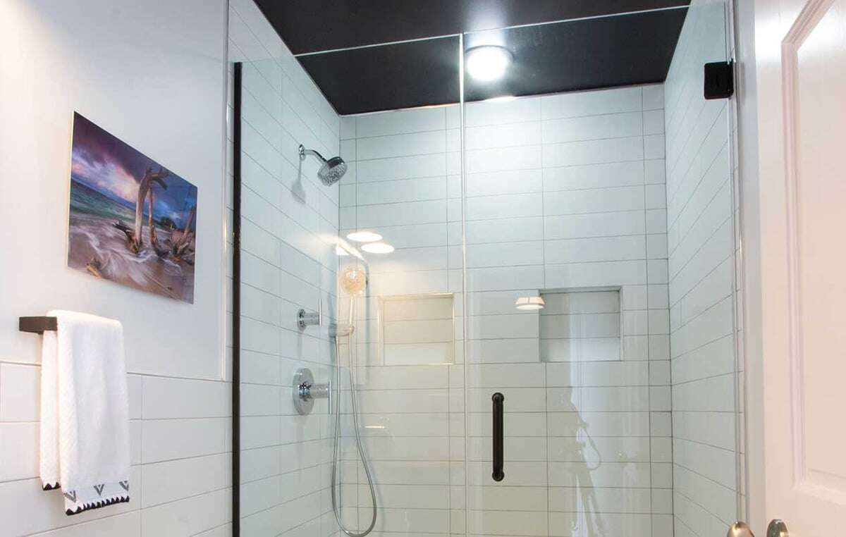 A walk-in shower with tile work that extends to the bathroom wall