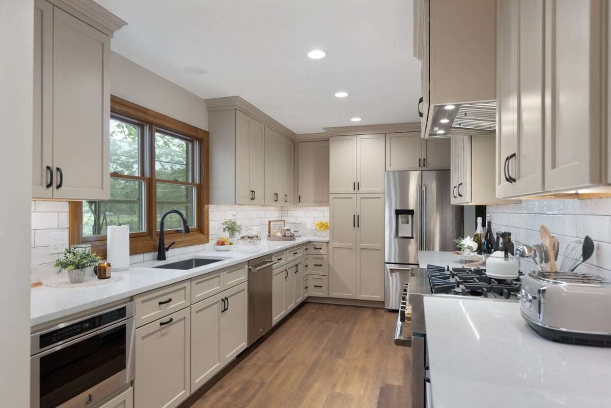 Georgeanna Kitchen with porcelain floors, multiple cabinets, sink and a wide window with hardwood beams