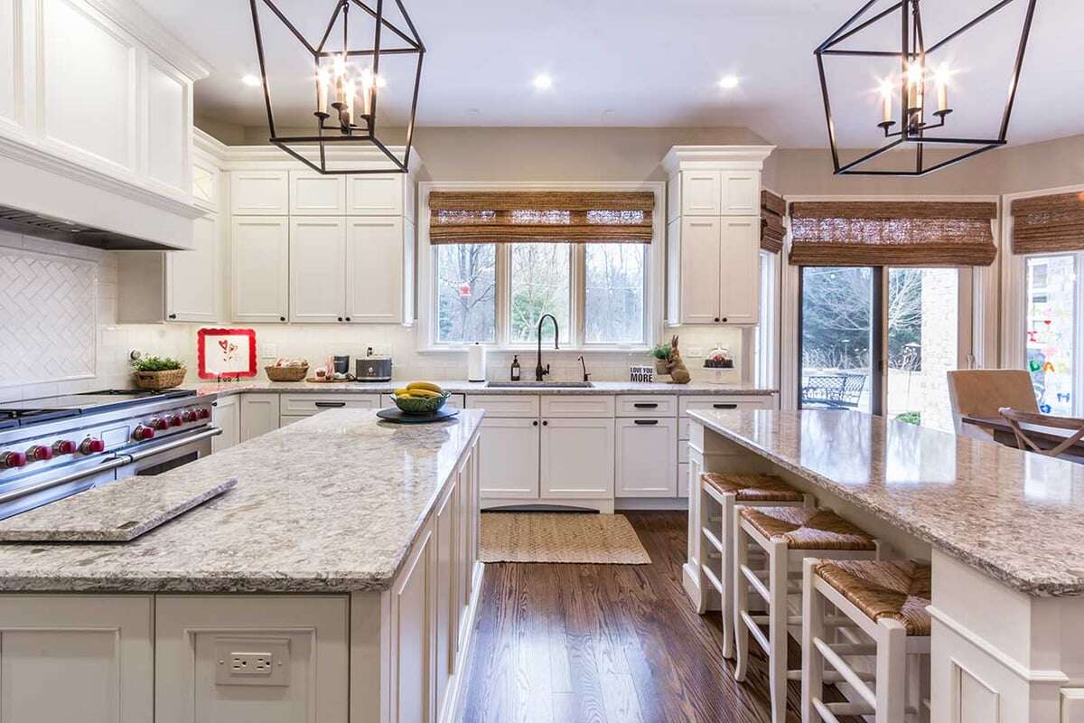 A Kitchen with wooden floor, a marble cooking countertop and marble dinning table with wooden dinning stools underneath