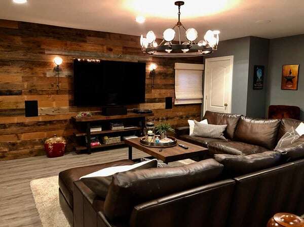 Basement Photo For Checklist featuring a warm and inviting environment, a wood accent wall, and chandelier, and a brown leather sectional