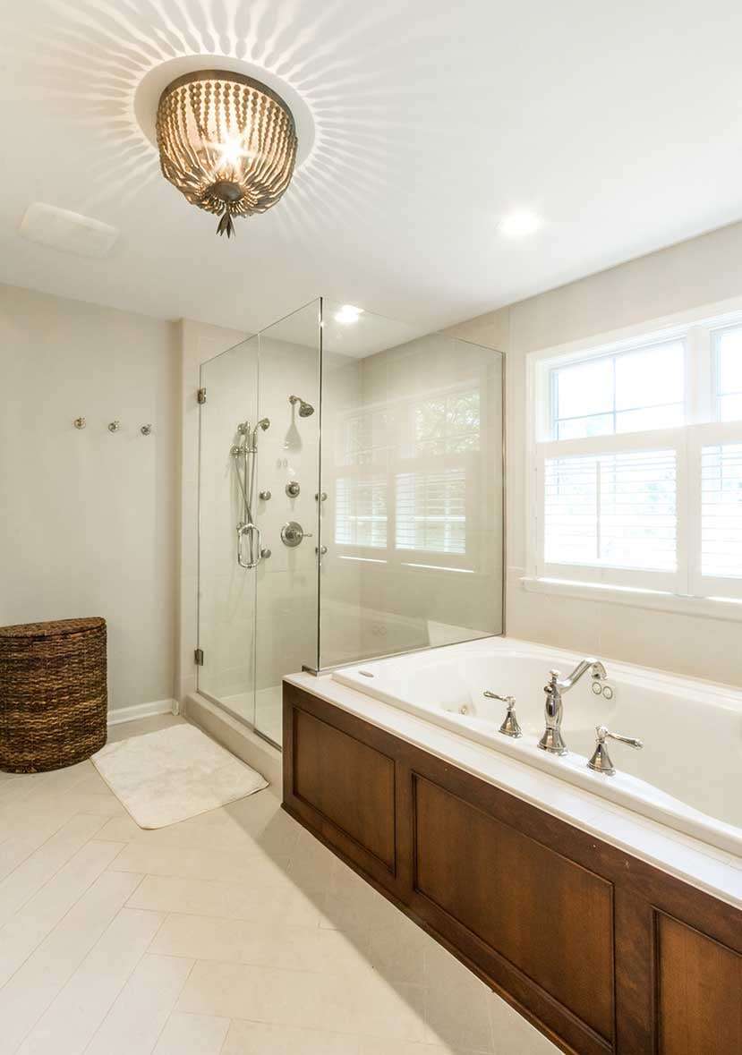 Bright and naturally lit bathroom with a built in tub and brow finishes around it