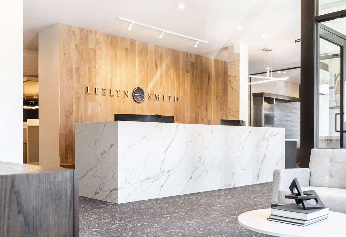 Front office of a commercial building with a service desk and a large brand behind the wall