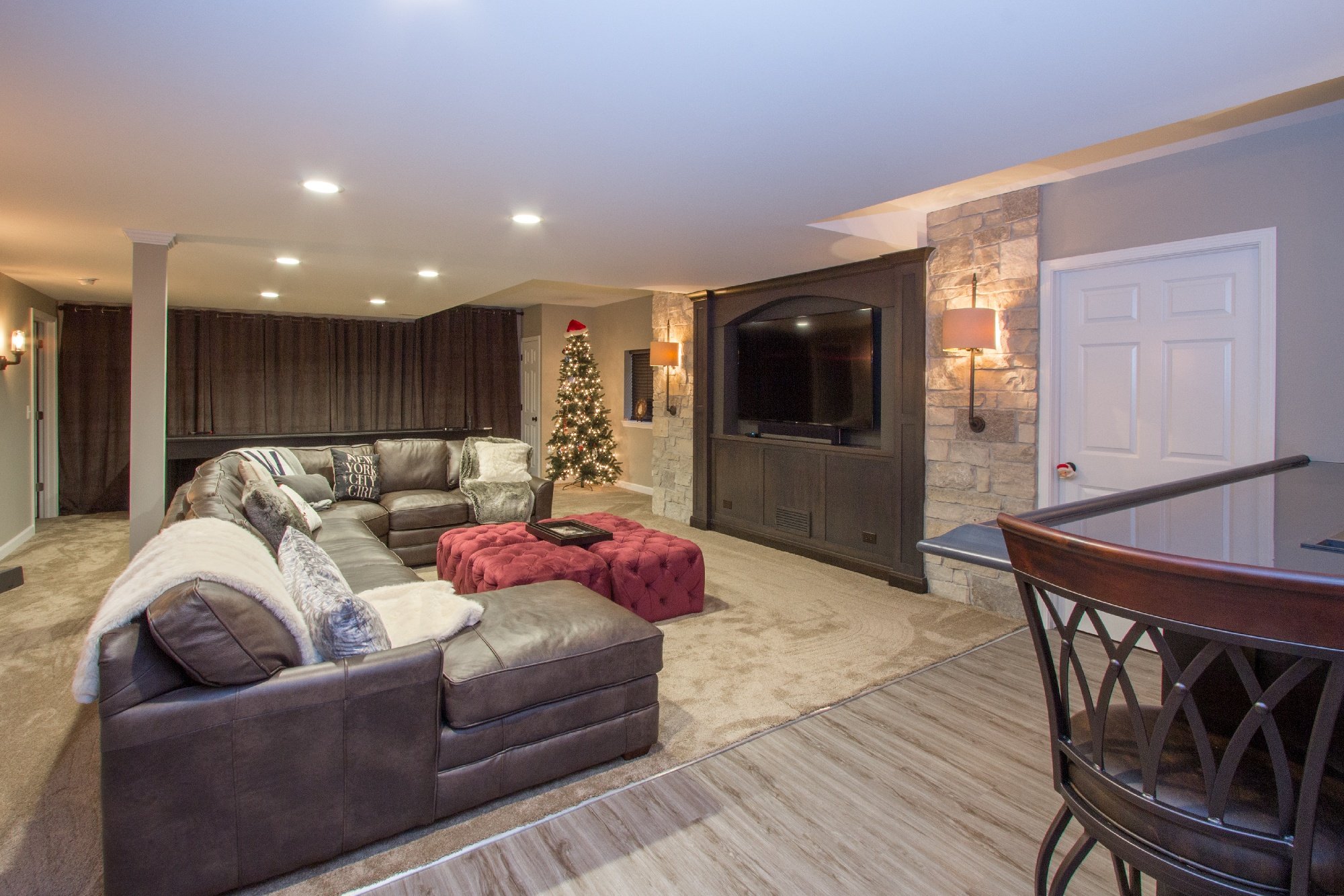 recently remodeled basement decorated for the holidays with a christmas tree and santa hat