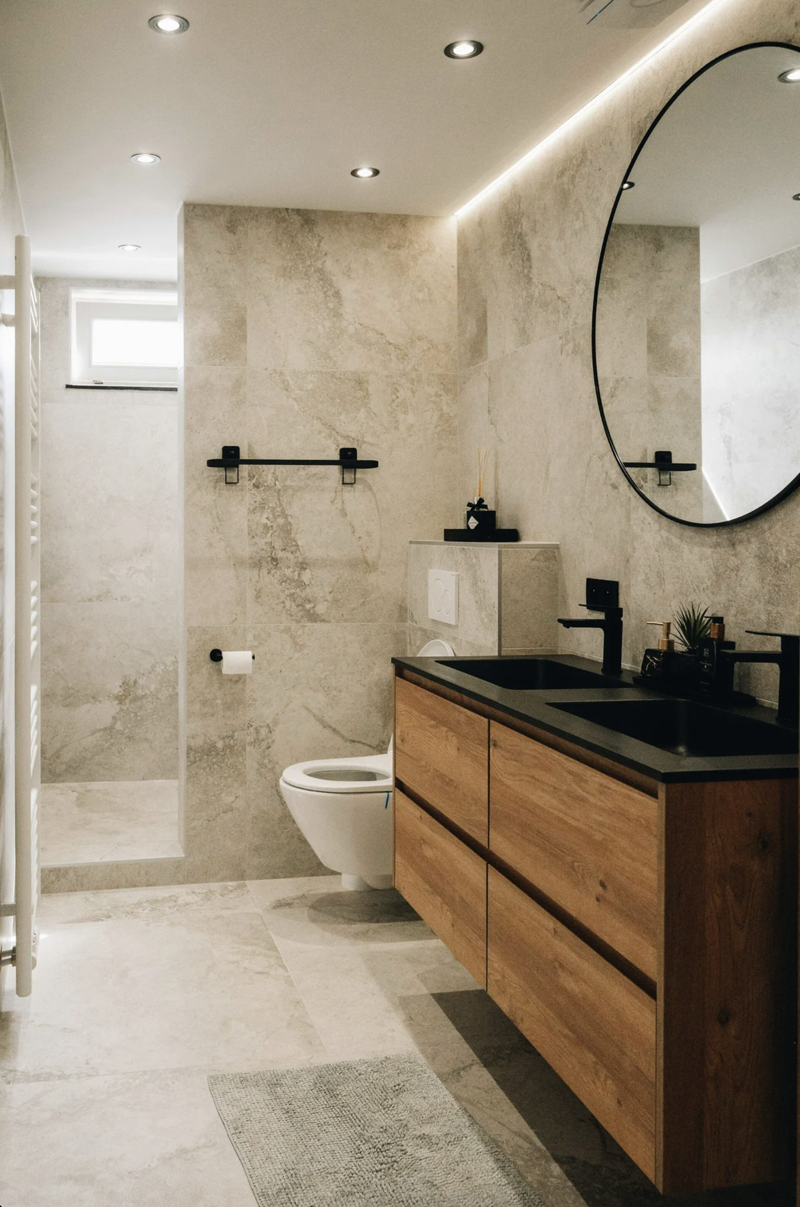 Luxurious and sleek bathroom with a single vanity countertop and a rounded oval shape mirror